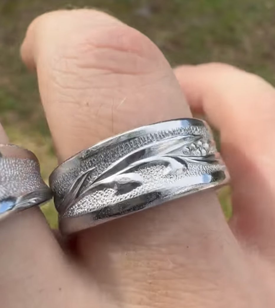 Wide band ring held between fingers